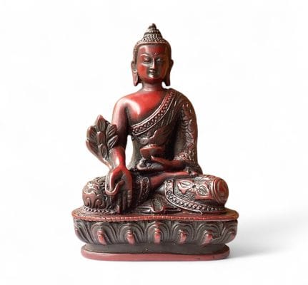 Cherry-colored Medicine Buddha statue in seated pose holding a bowl and healing herb, symbolizing wellness and spiritual healing.